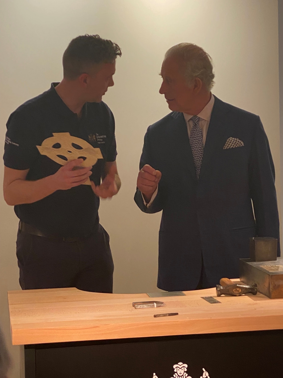 Liveryman Adam Phillips helps His Majesty hallmark a processional cross